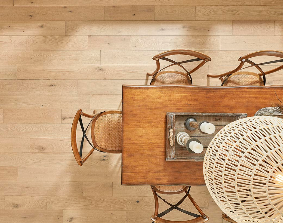 DIY laminate flooring adds a natural look to a dining room featuring a rustic table and chairs.